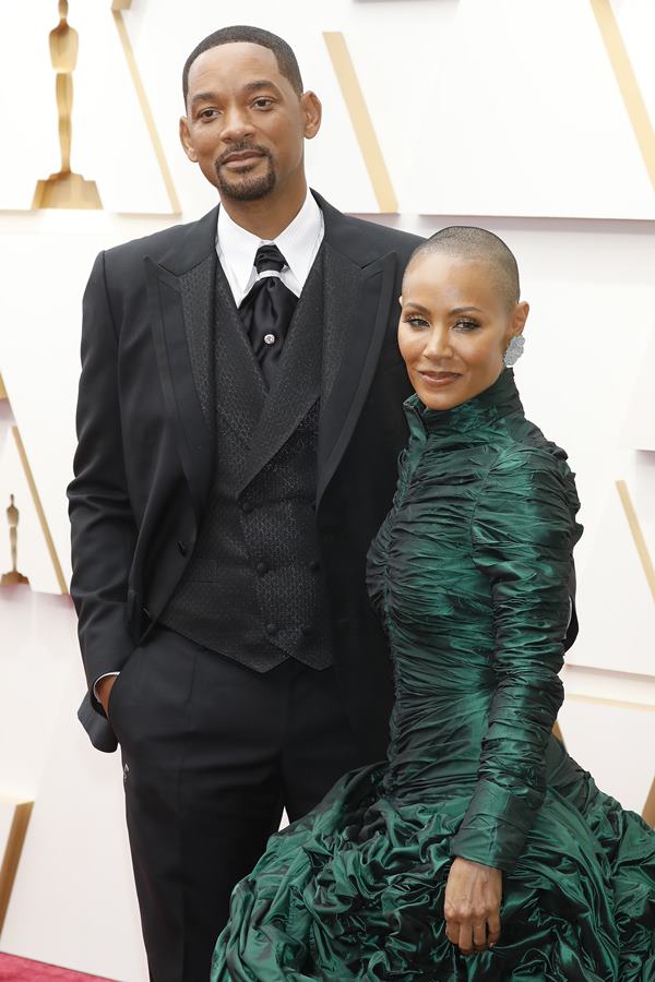 Casal em tapete vermelho com roupas de gala