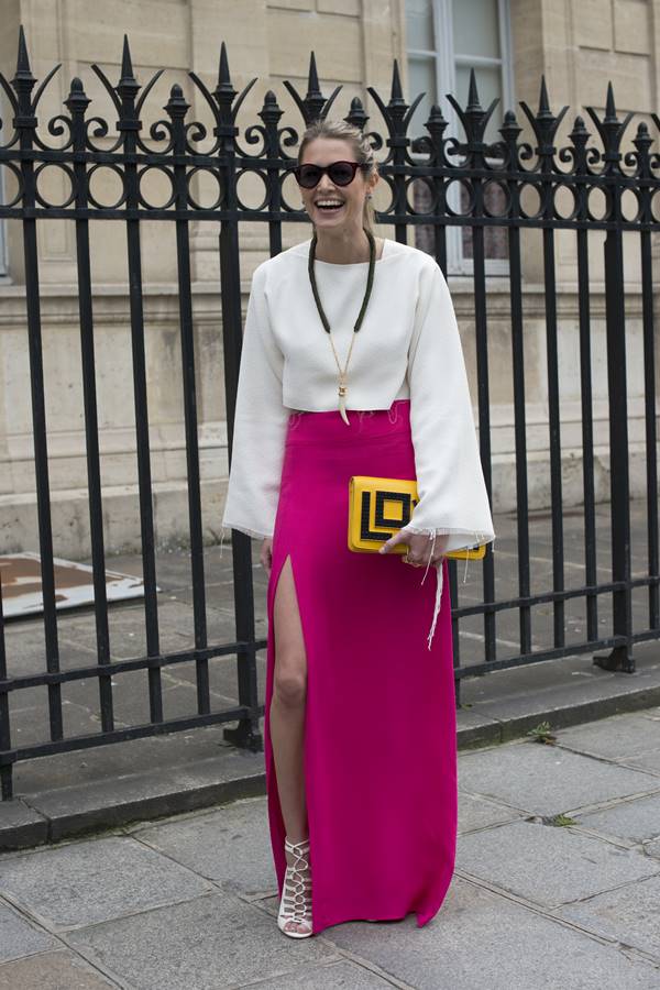 Look com saia rosa magenta, bolsa clutch amarelo e blusa branca de mangas compridas - Metrópoles