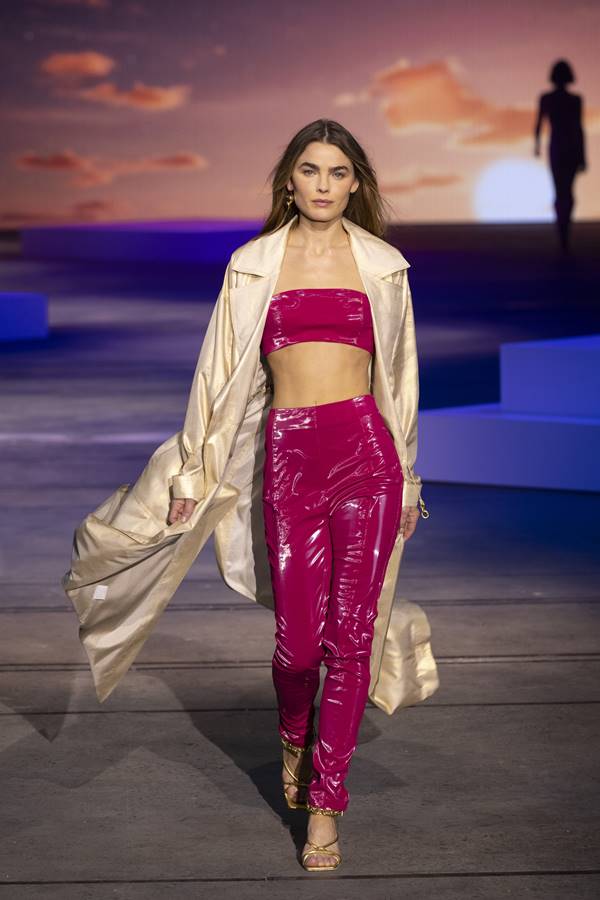 Na passarela, modelo usa look com calça e top sem alças na cor magenta - Metrópoles