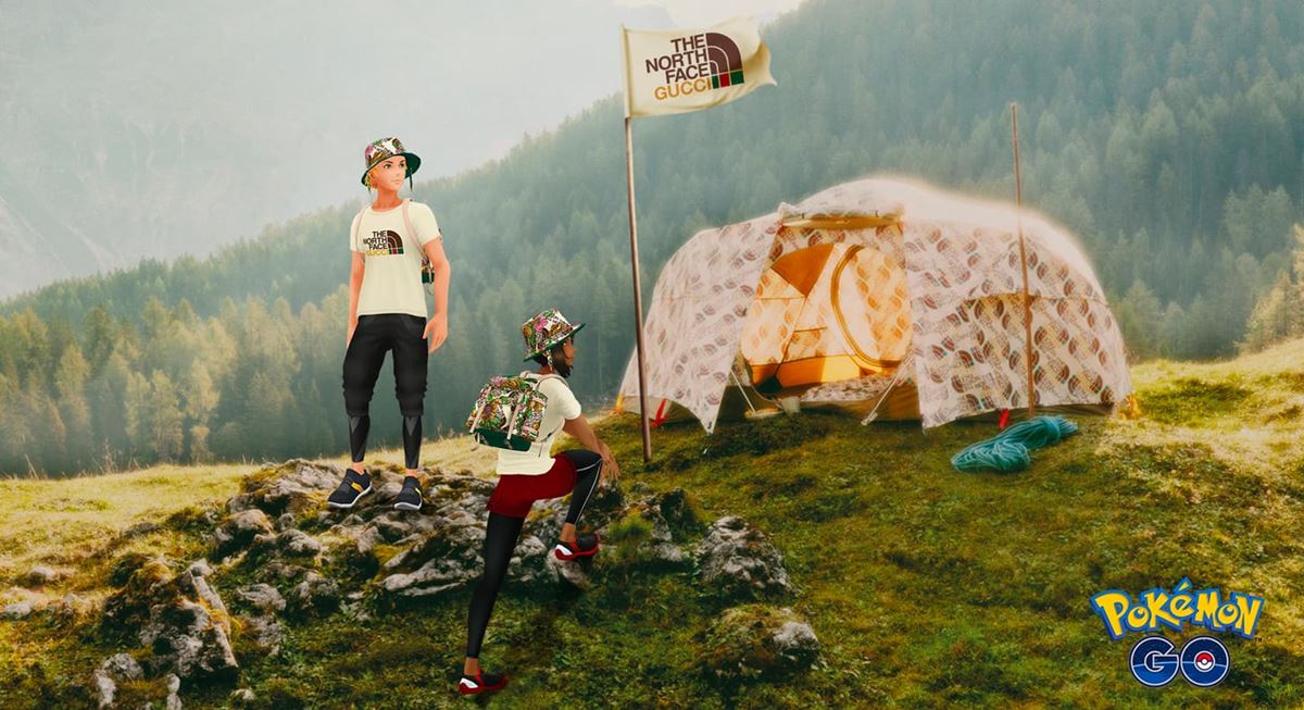 Cena do jogo Pokémon Go. Na imagem, dois personagens virtuais brancos e jovens usam roupas da coleção da Gucci com a marca The North Face. Os dois estão em uma região montanhosa, ao lado de uma barraca de acampar. - Metrópoles