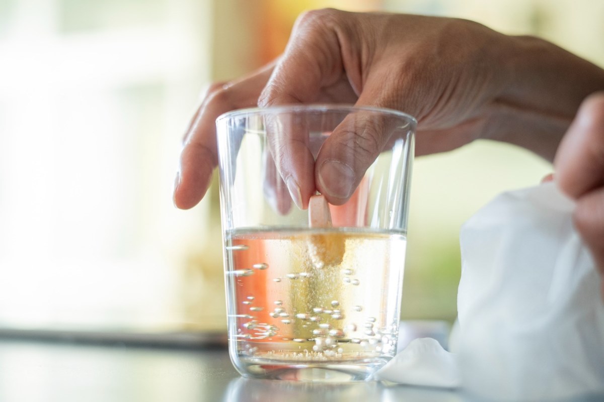 Foto colorida de copo com vitamina C sendo diluída