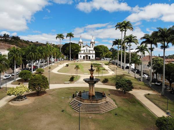 Praça com escultura e igreja ao fundo