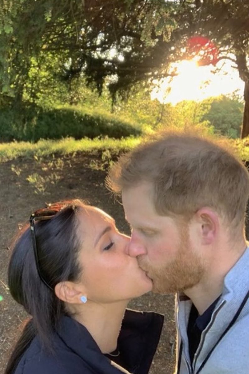 Foto colorida de mulher parda beijando homem branco e ruivo em um bosque - Metrópoles