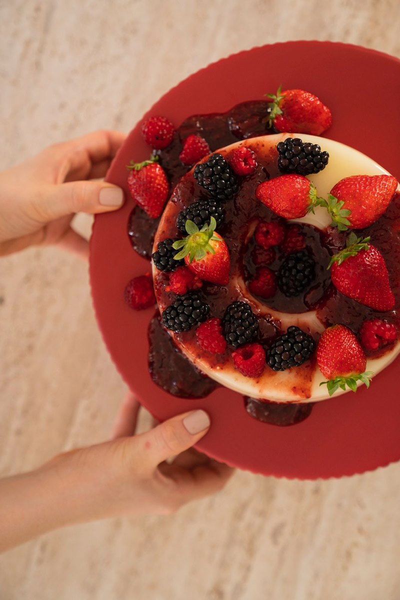 Foto colorida de torta com furo ao meio e ao redor com frutas vermelhas - Metrópoles