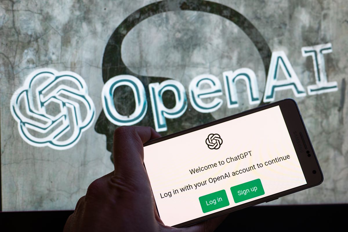Foto colorida de tela de celular com o fundo cinza e a palavra escrita OpenAI - Metrópoles 