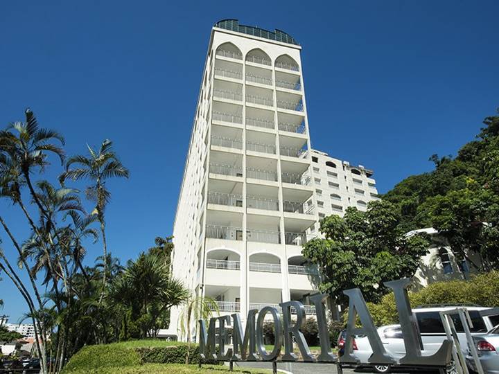 Foto de construções alta e brancas em meio à árvores e grama