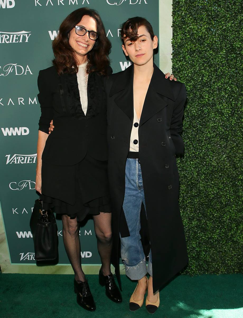 As stylists Elizabeth Stewart e Karla Welch, mulheres brancas e jovens, em evento de moda do Council of Fashion Designers of America, CFDA, em 2018. Ambas usam blazers pretos e usam saltos baixos. - Metrópoles