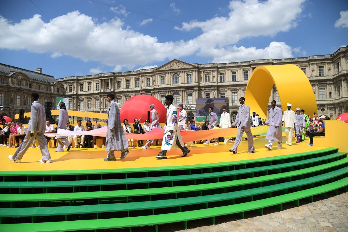 Desfile da linha masculina da marca francesa Louis Vuitton. A apresentação corre em um palco amarelo em frente a um museu em Paris, na França. Uma fila de modelos homens jovens, a maioria negra, cruza a passarela. - Metrópoles