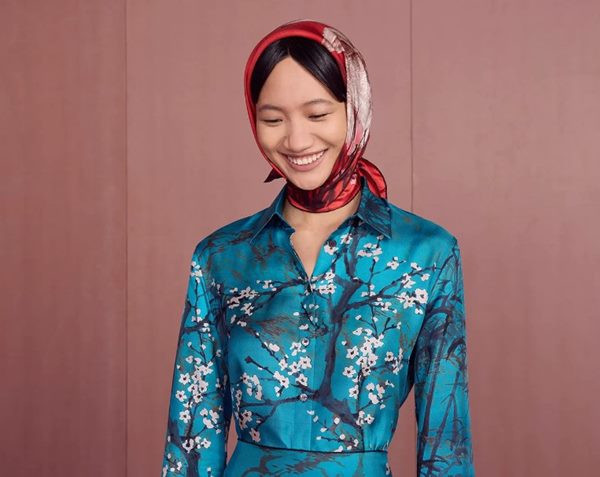 Mulher com lenço no cabelo. Ela está sorrindo para a foto - Metrópoles