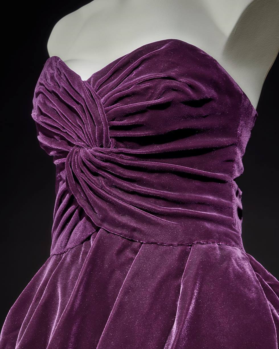 Vestido roxo de veludo, sem alça e com um bustiê franzido, da coleção de outono de 1989 do estilista Victor Edelstein. A peça, feita em tecido camurça, foi usada pela princesa Diana. - Metrópoles