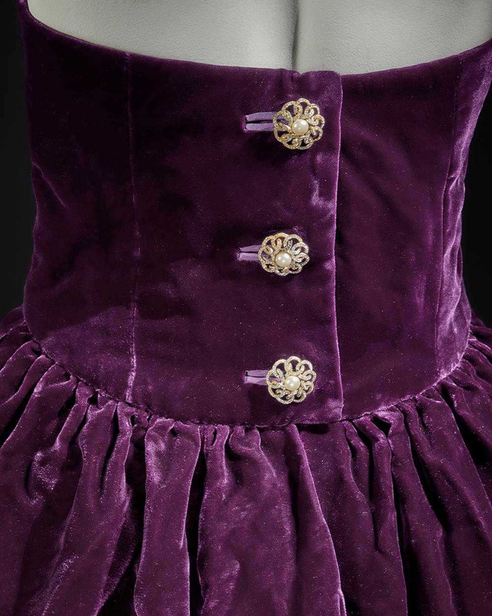 Vestido roxo de veludo, sem alça e com um bustiê franzido, da coleção de outono de 1989 do estilista Victor Edelstein. A peça, feita em tecido camurça, foi usada pela princesa Diana. - Metrópoles