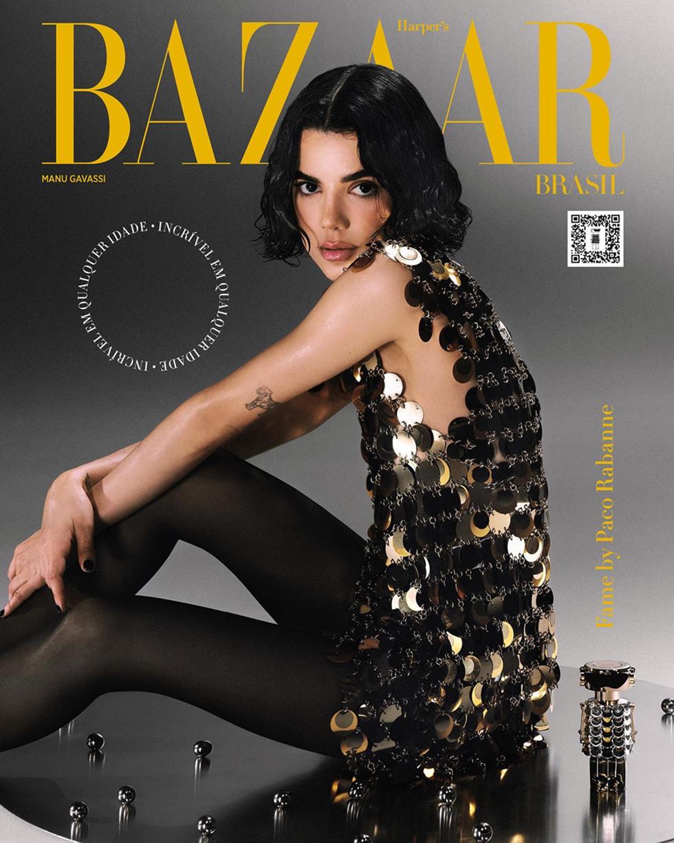 Capa da revista Harper's Bazaar. Na foto, posa a cantora e ex-BBB Manu Gavassi, uma mulher branca e jovem, de cabelo ondulado curto e castanho. Ela usa um vestido de lantejoulas dourado e uma meia calça preta. - Metrópoles