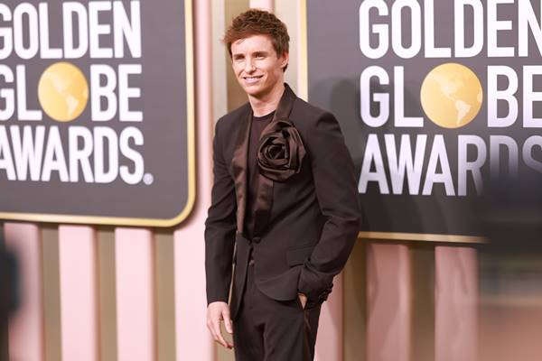 Eddie Redmayne usa terno preto Valentino com broche de maxi laço - Metrópoles