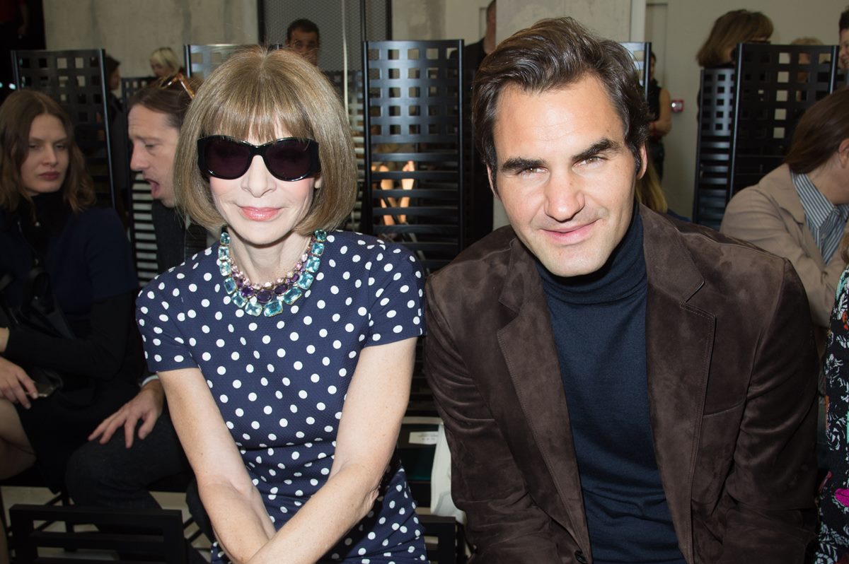 A jornalista de moda Anna Wintour, uma mulher branca e idosa, ao lado do tenista Roger Federer, um homem branco, de meia idade e com cabelos lisos na cor castanha. - Metrópoles