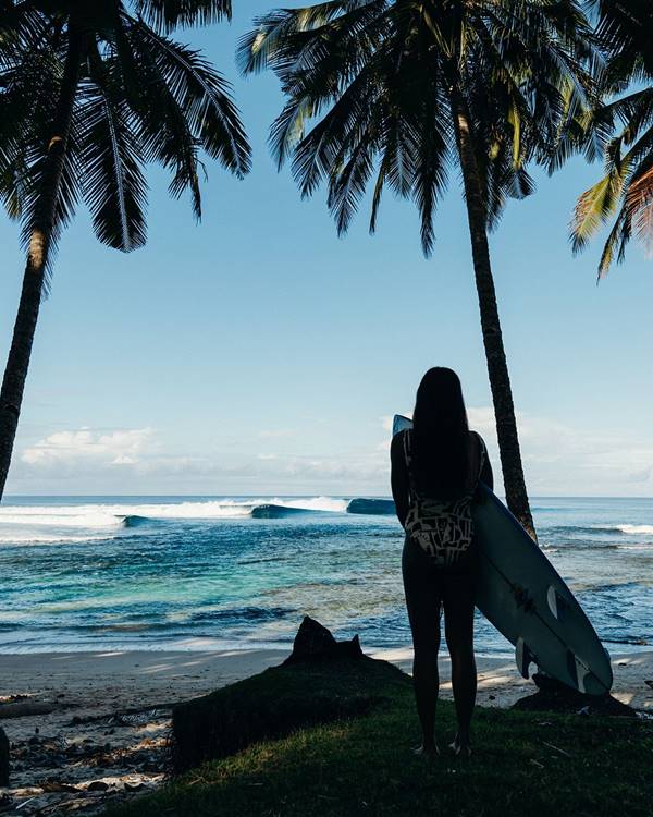 Sophia Medina com biquini branco ao lado de uma prancha de surfe saindo do mar - Metrópoles 