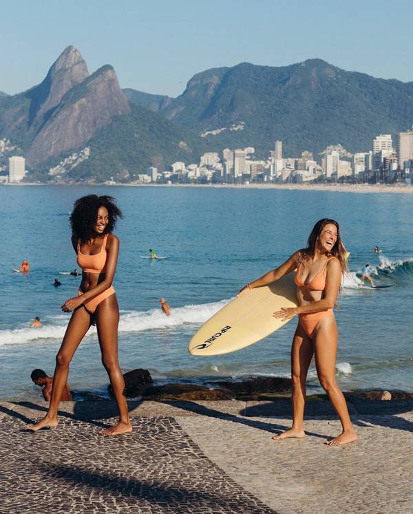 Modelos na praia de biquini seguram prancha na praia - Metrópoles 