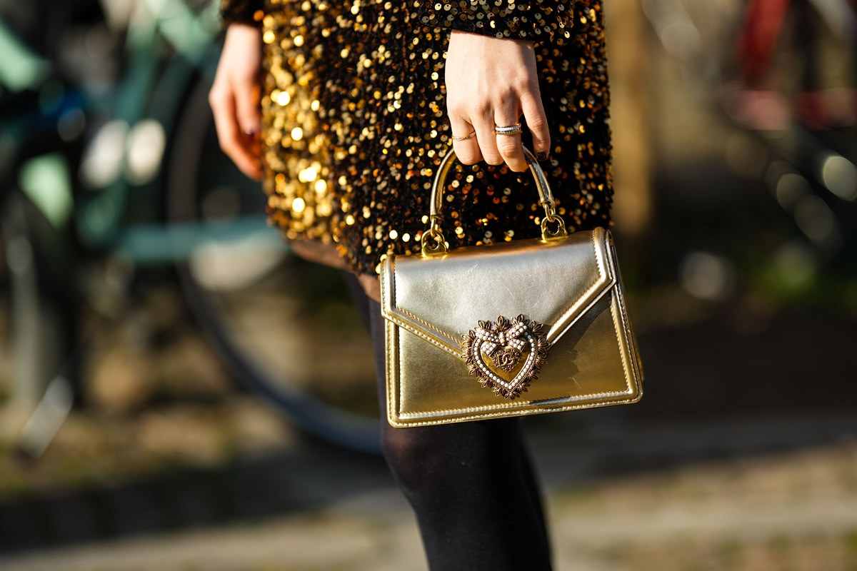 Bolsa Devotion da grife Dolce & Gabbana. A peça é feita em couro dourado e possui um fecho, também dourado, em formato de coração. - Metrópoles