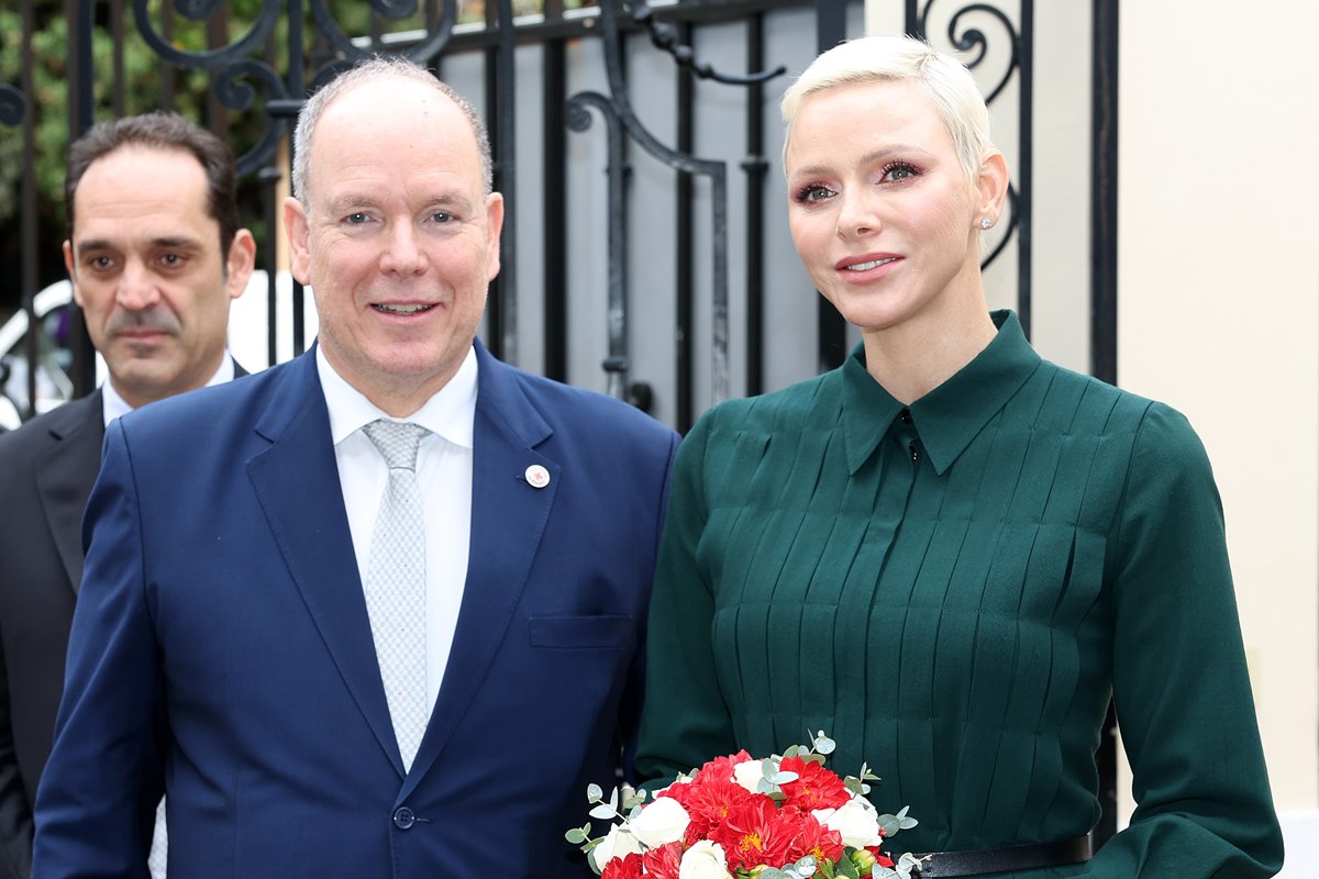 Foto colorida de homem branco, careca e de terno ao lado de mulher branca, com cabelo platinado e vestido verde- Metrópoles