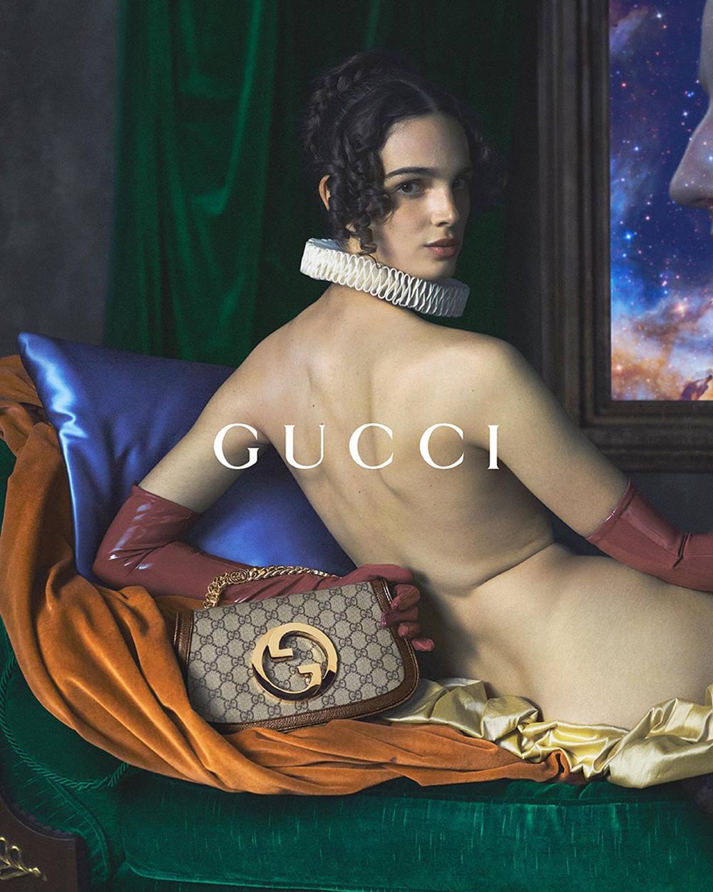 Campanha publicitária da marca Gucci. Na imagem, uma mulher branca e jovem está semi nua e usa apenas luvas vermelhas. Ela segura uma bolsa bege da marca com fecho dourado. - Metrópoles