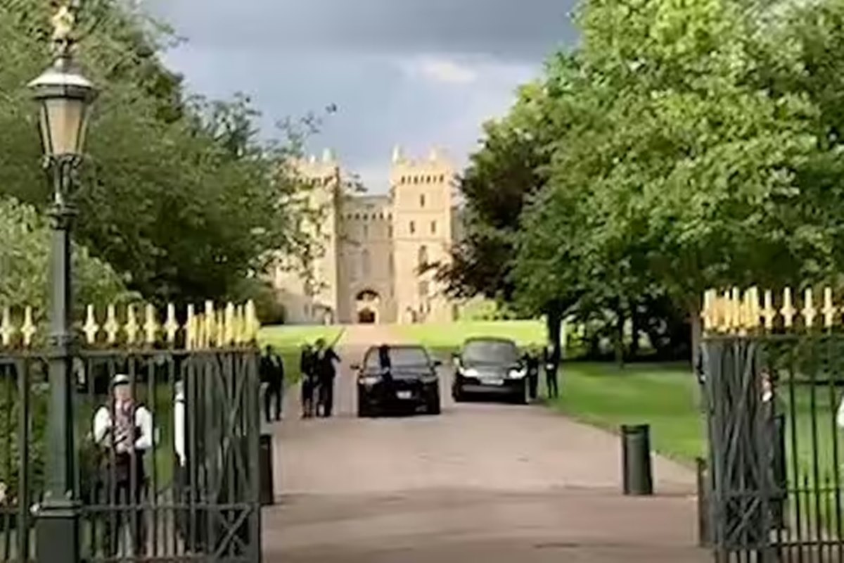 Foto colorida de pessoas em frente a um castelo - Metrópoles