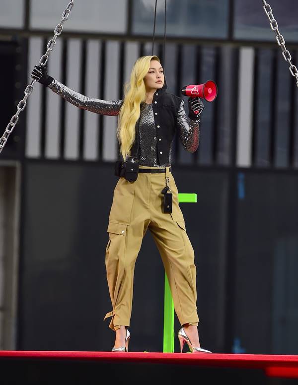 Modelo Gigi Hadid usa calça cargo na cor bege, blusa de manga longa em couro e sandália de salto alto - Metrópoles 