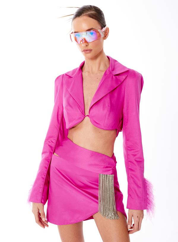 Modelo usa blazer cropped e saia com brilhos, em look rosa, além de óculos futurista - Metrópoles