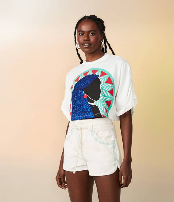 Modelo usa camiseta branca com estampa de mulher negra ilustrada e short branco - Metrópoles