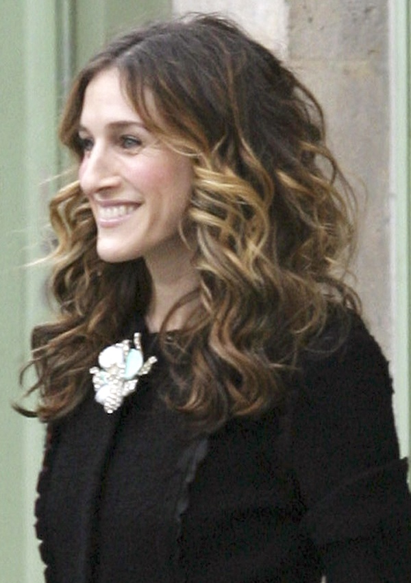 Atriz Sarah Jessica Parker usa casaco preto e broche de flor branco - Metrópoles 