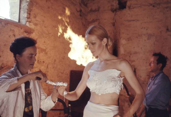 Claude Lalanne moldando corpo de modelo para escultura corporal em collab com Yves Saint Laurent. A modelo está com uma pasta branca nos seios - Metrópoles