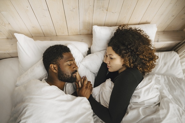 Casal deitado na cama - Metrópoles