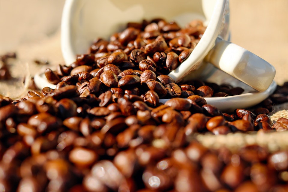 Na foto, uma xícara derramando grãos de café - Metrópoles