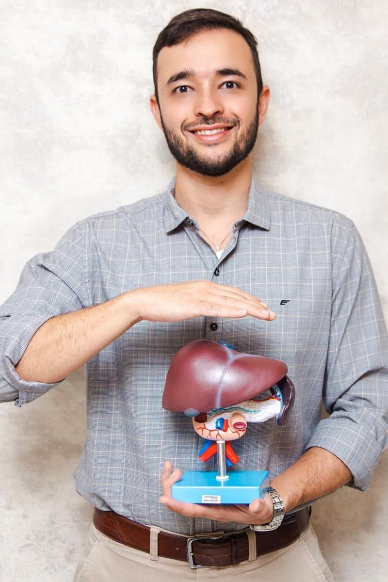 Foto colorida de homem pardo, com barba, segurando uma maquete com órgãos do corpo humano - Metrópoles