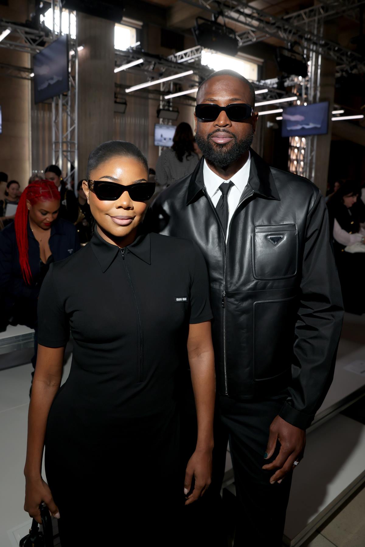 A atriz Gabrielle Union e o marido, o jogador de basquete, Dwayne Wade, no desfile da Miu Miu na Semana de Moda de Paris. Os dois são negros e de meia idade e usam roupas pretas e óculos escuros. - Metrópoles