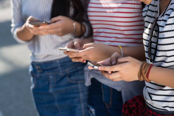 Fotografia colorida mostrando três pessoas mexendo no celular-Metrópoles