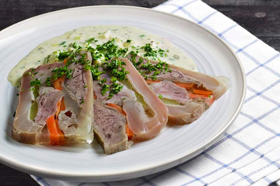 Tête de veau da França em um prato branco em cima de uma toalha quadrada