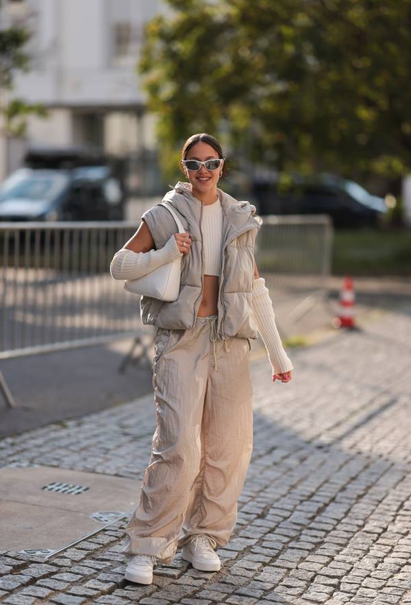 Look com calça paraquedas e colete puffer no street style - Metrópoles