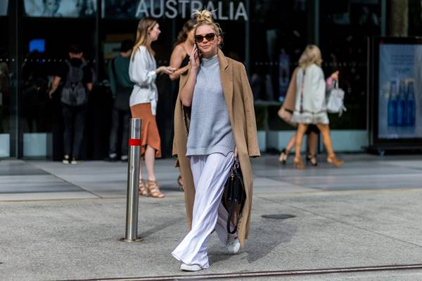 Mulher andando na rua e falando ao celular - Metrópoles