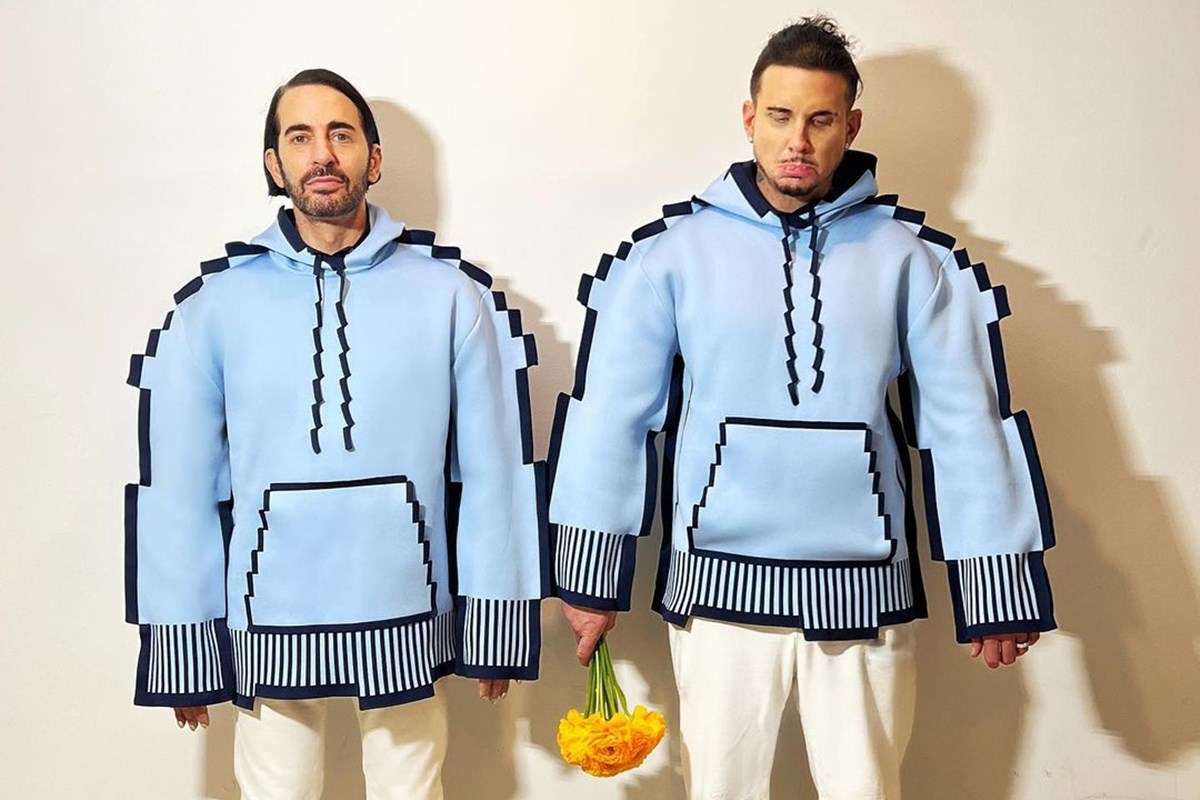Dois homens posando para foto. A dupla está usando casacos pixelados - Metrópoles