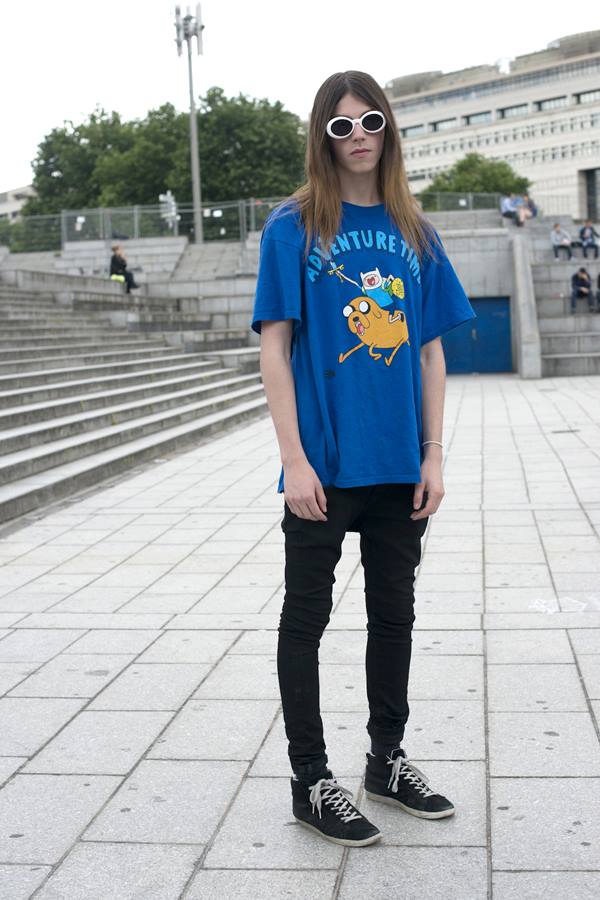 Homem posando para foto em uma praça. Ela está usando camiseta azul e óculos de sol - Metrópoles