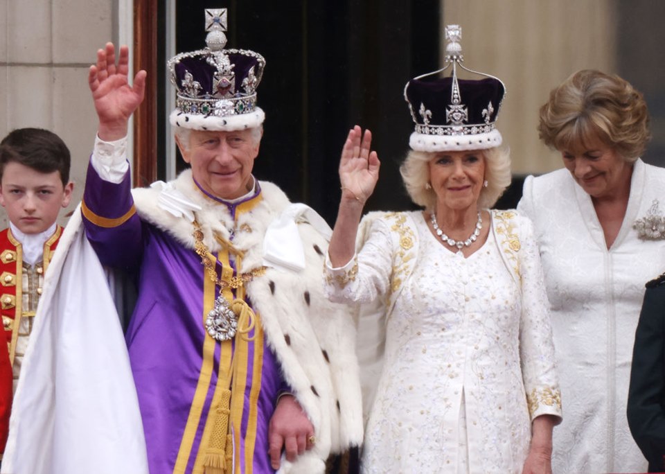 Rei Charles III e rainha Camilla acenam para os presentes na varanda do Palácio de Buckingham