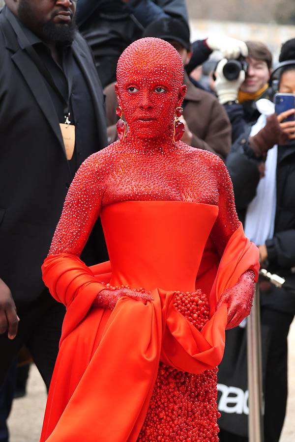 Na imagem com cor, uma mulher coberta por cristais vermelhos e vestido vermelho - Metrópoles 