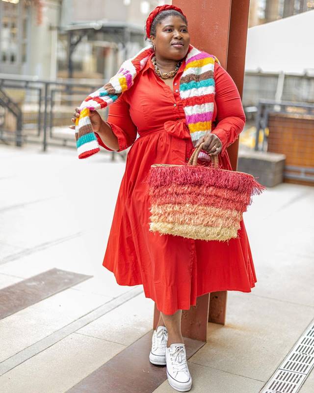 Na imagem com cor, uma mulher gorda negra, usando um vestido laranja e tênis branco - Metrópoles