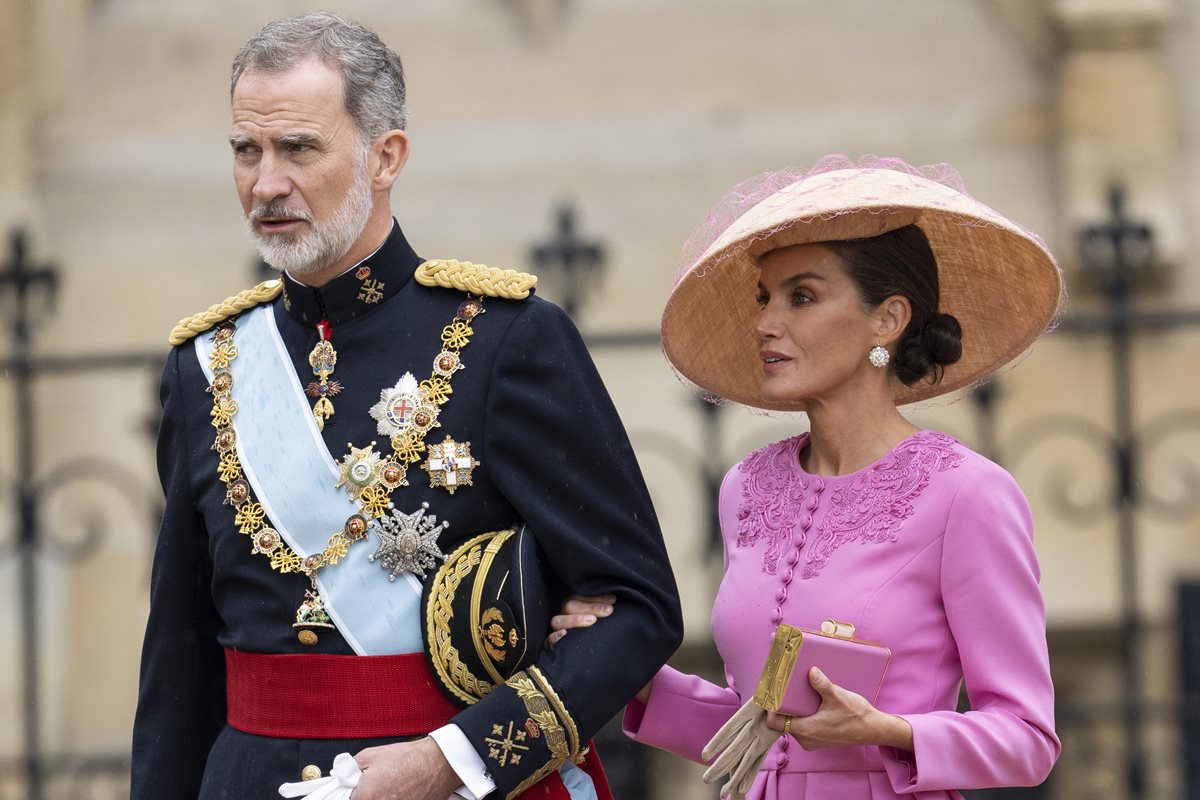 Foto colorida de homem idoso, com trajes militares, ao lado de mulher parda com roupa e chapéu cor-de-rosa - Metrópoles