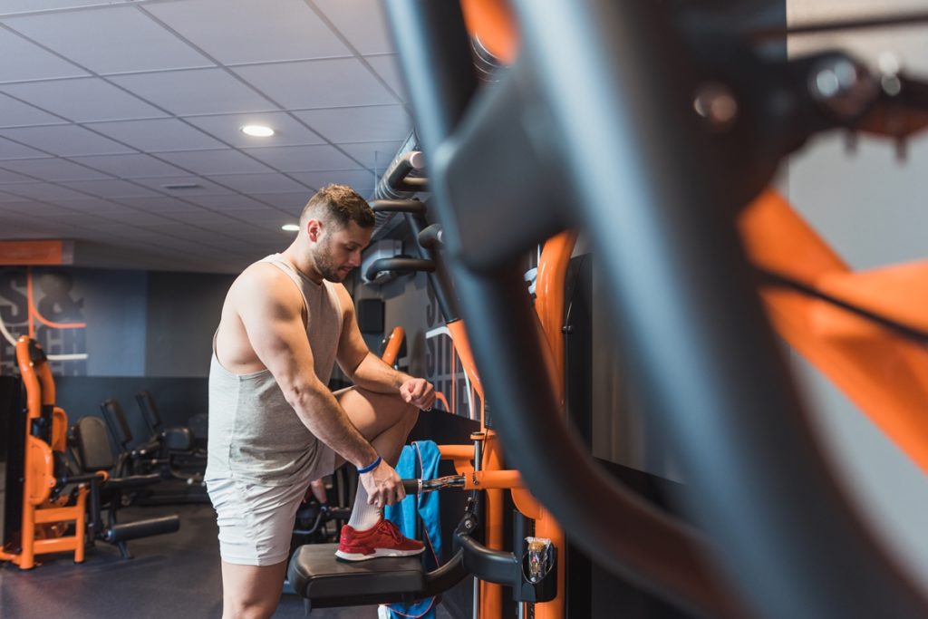 Foto colorida de um homem fazendo musculação na academia - Metrópoles