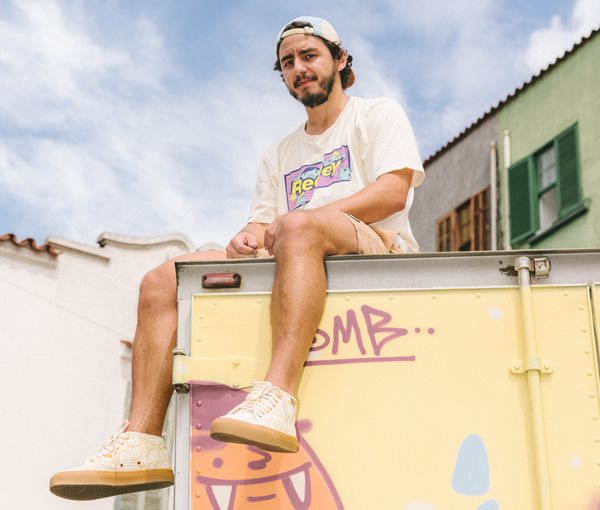 Homem sentando em contairner grafitado - Metópoles