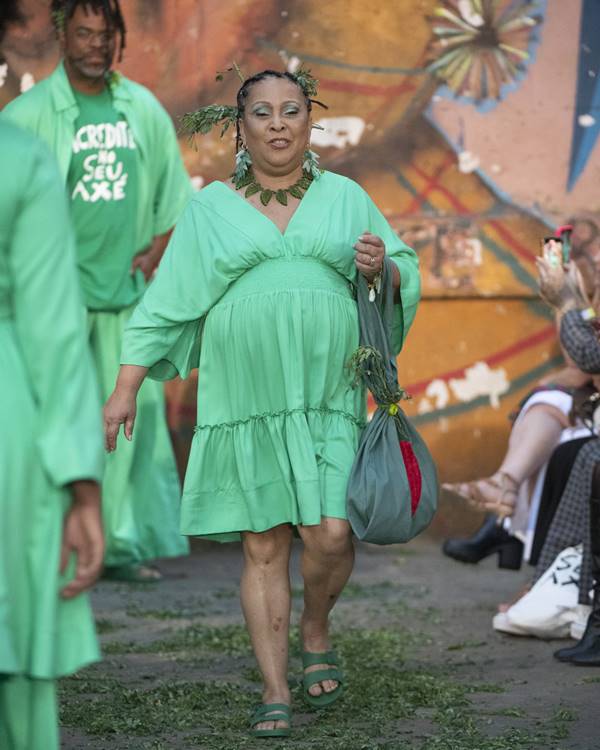 Mulher usando vestido verde em passarela - Metrópoles