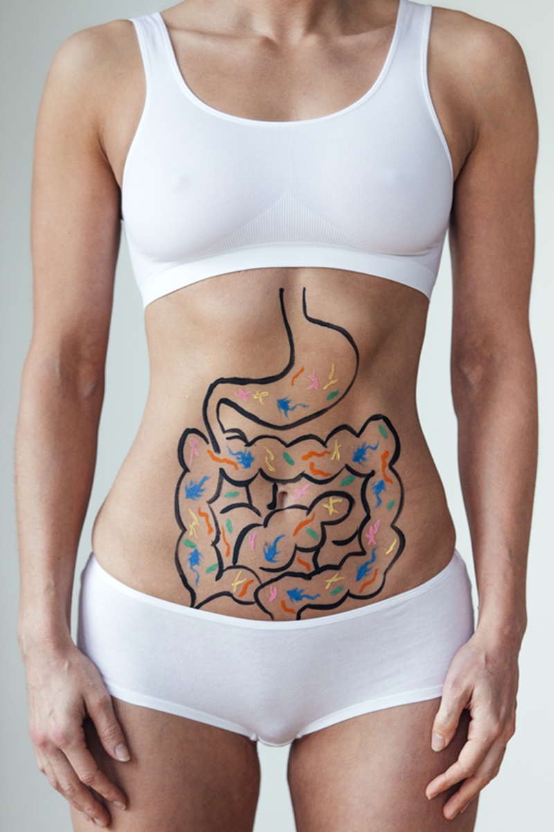 Foto de intestino desenhado em abdômen de mulher com top e microshort na cor branca - Metrópoles