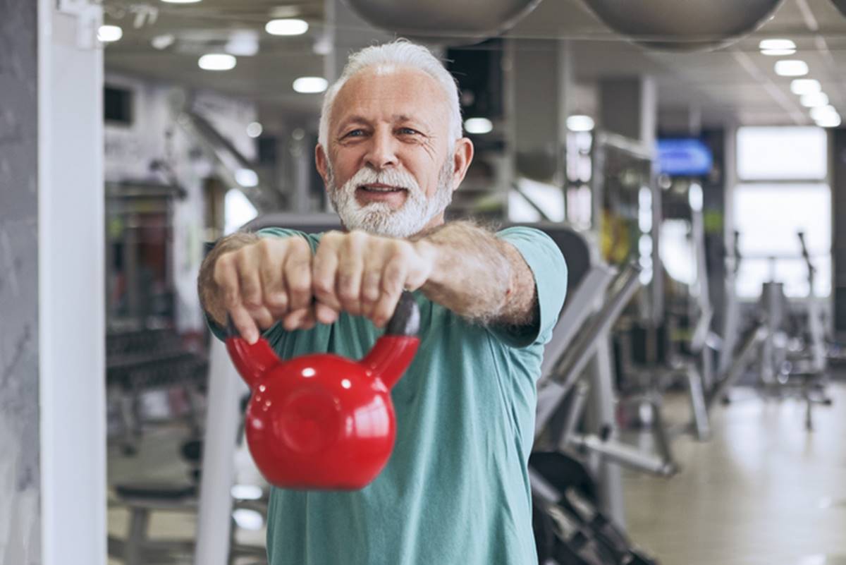 Imagem colorida: idoso levanta peso de musculação na academia - Metrópoles