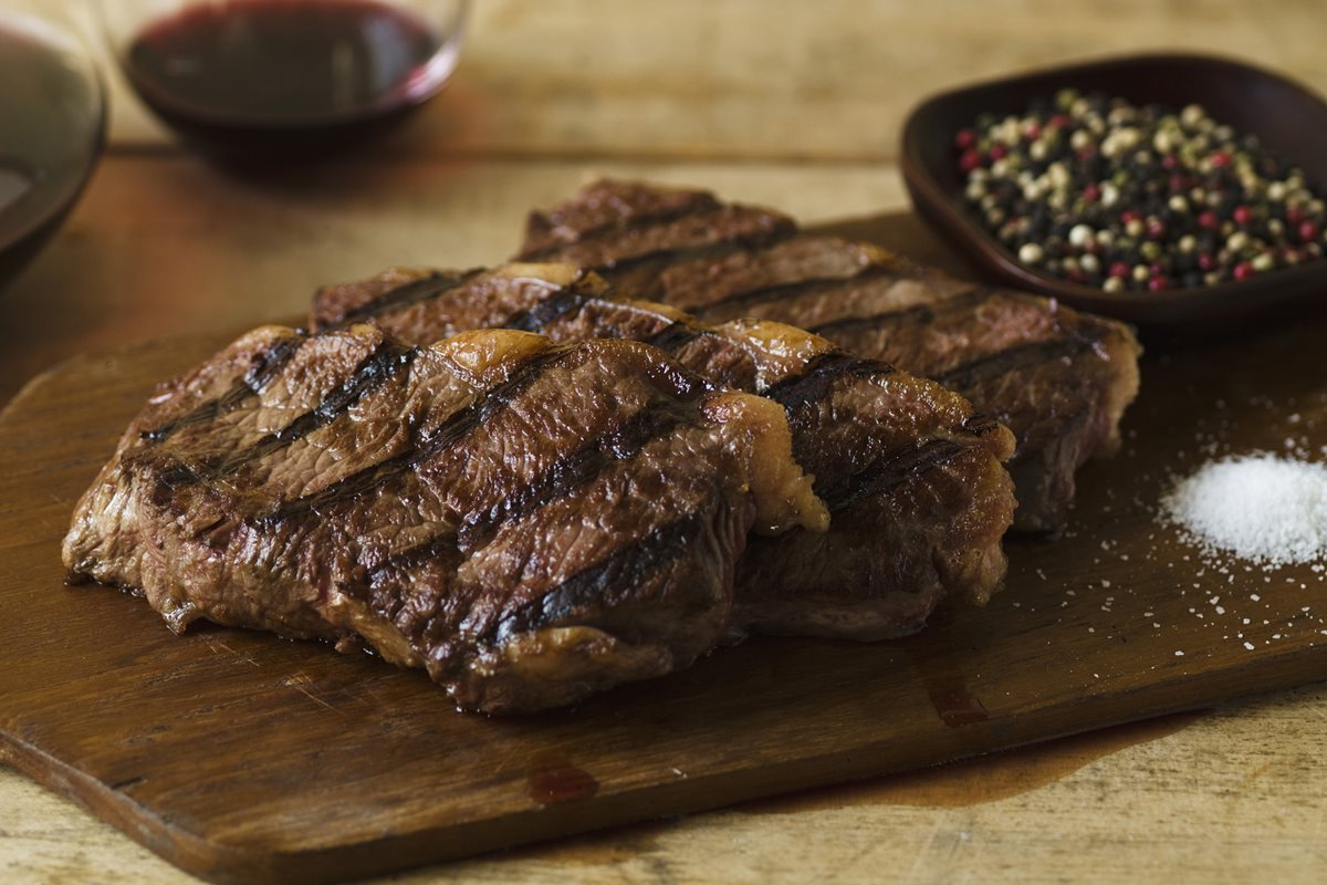 Foto colorida de filés de carne em uma tábua - Metrópoles