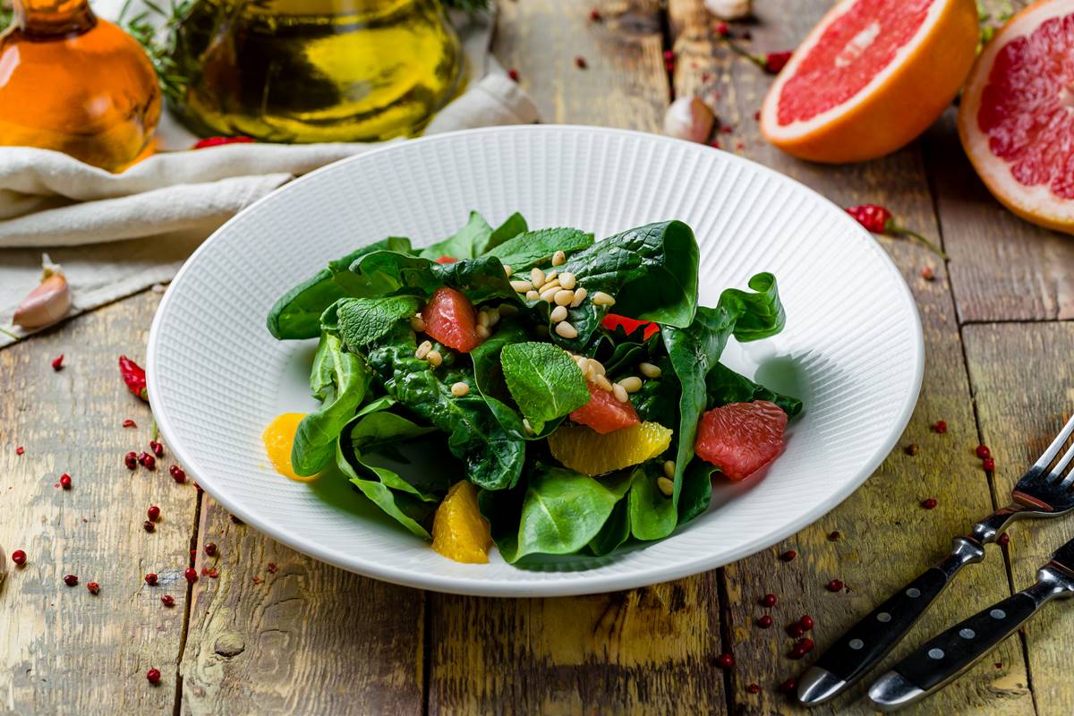 Foto colorida de prato branco com salada dentro - Metrópoles